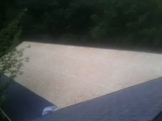 New OSB roof sheathing installed beside an existing shingle roof in Baldwin