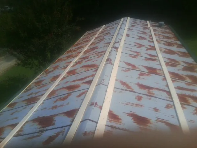 Rusted metal roof panels with new wood purlins before replacement — Storm Damage Roof Repair in Baldwin by Roofing Brothers